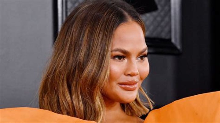 Chrissy Teigen Shows Off Her Growing Baby Bump In A Stunning Cut Out Bathing Suit