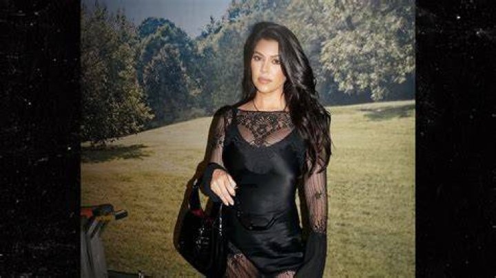 Kourtney Kardashian Stuns In Cutout Midi Dress As She Poses Seductively On Bed