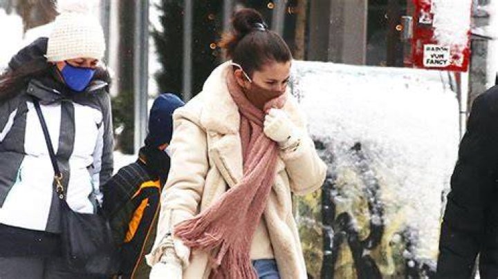 Selena Gomez Braved The NYC Cold In A Chic White Wrap Coat & You Can Shop A Similar Look For Under $100