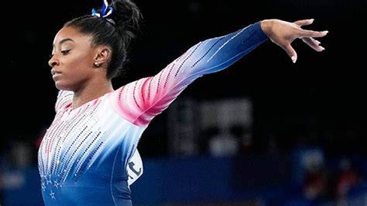 Simone Biles Rocks A Floral Bikini & Strikes A Pose On The Beach