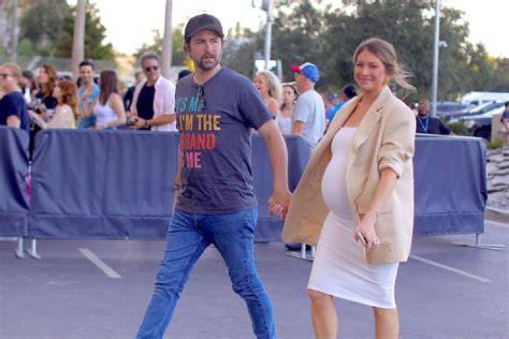 Stassi Schroeder & Beau Clark Cradle Her 25-Week Baby Bump In A Tight White Dress – Pic